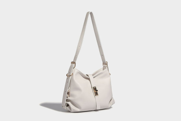 Soft slouchy hobo shoulder bag with smooth leather-look finish, gold-tone buckle and tab hardware, and long adjustable strap