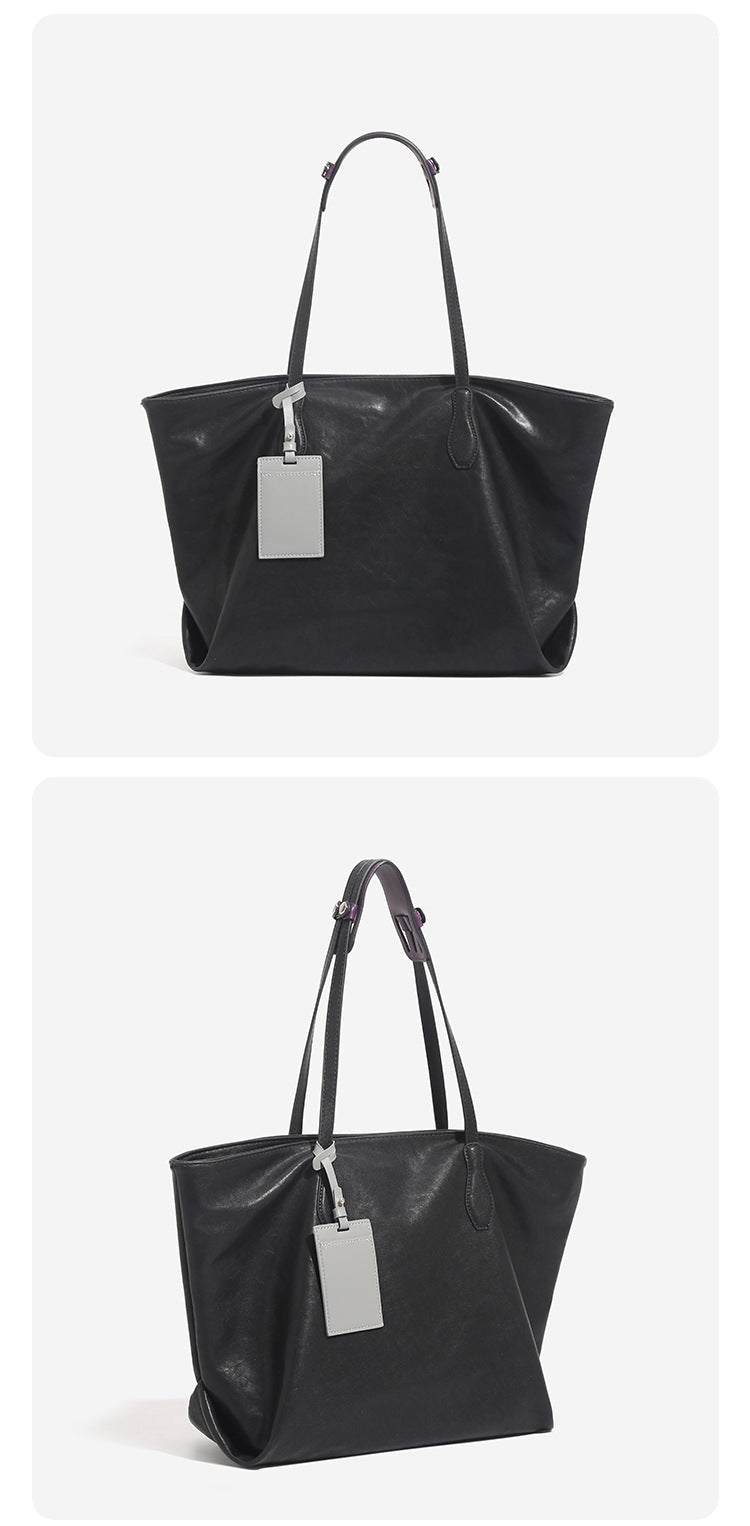 Large leather-look tote bag with trapezoid silhouette, double shoulder straps, and detachable hanging tag, detail view 11