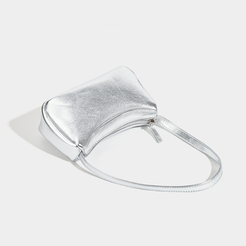 Compact curved silver metallic shoulder bag with top zip closure and slim single strap, detail view 3