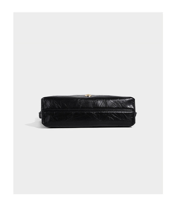 Large slouchy hobo shoulder bag in glossy crinkle leather-look finish with gold-tone emblem hardware and adjustable strap
