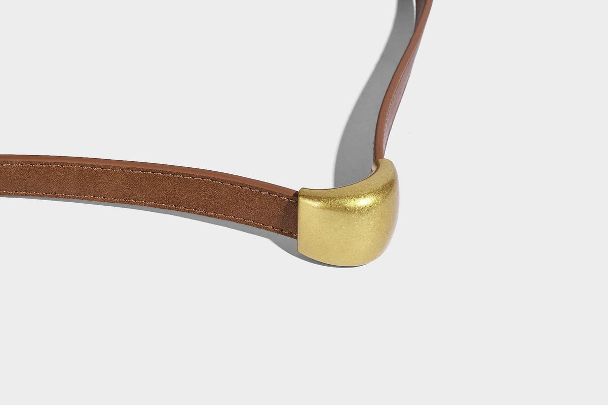 Beige-braune Hobo-Schultertasche mit lässiger Silhouette, matter Veloursleder-Optik, goldfarbenen halbmondförmigen Beschlägen und schmalem Schulterriemen, Detailaufnahme