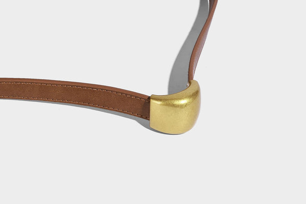 Beige-braune Hobo-Schultertasche mit lässiger Silhouette, matter Veloursleder-Optik, goldfarbenen halbmondförmigen Beschlägen und schmalem Schulterriemen, Detailaufnahme