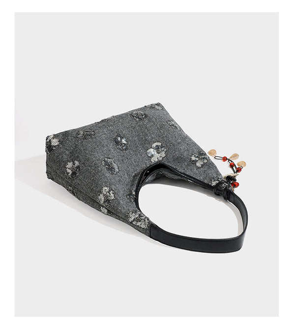 Lässig fallende, trapezförmige Schulter-Tote in Anthrazitgrau mit floralen Paillettenmotiven in Silber, Riemen in Lederoptik und herabhängendem Perlenbesatz