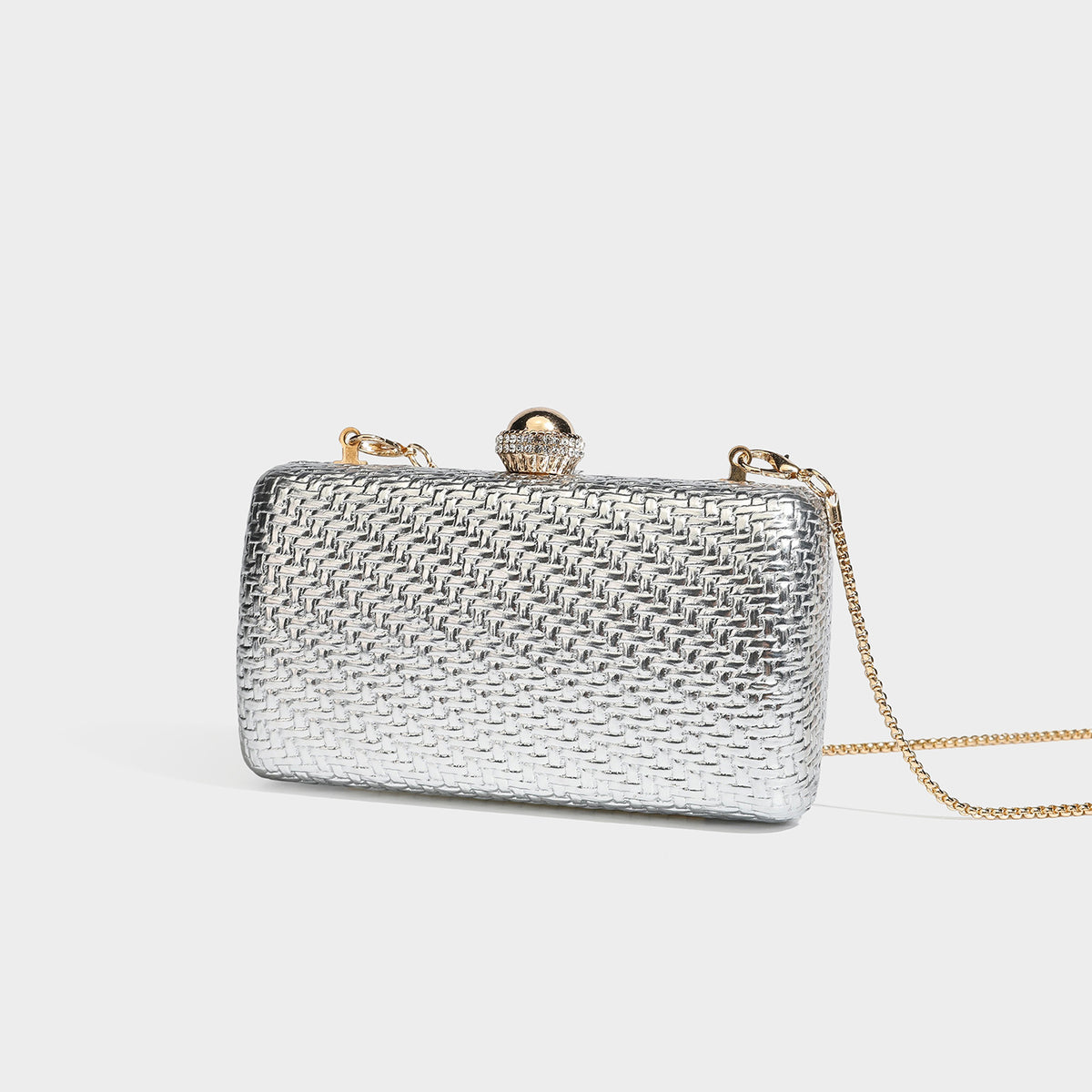 Small structured metallic woven-texture box clutch bag with jeweled kiss-lock dome clasp and slim gold chain strap, detail