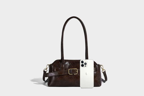 Strukturierte dunkelbraune Henkeltasche mit Öl-Wachs-Finish, vorderer Gürtelschnalle, goldfarbenen Beschlägen und zwei Tragegriffen, Detailansicht