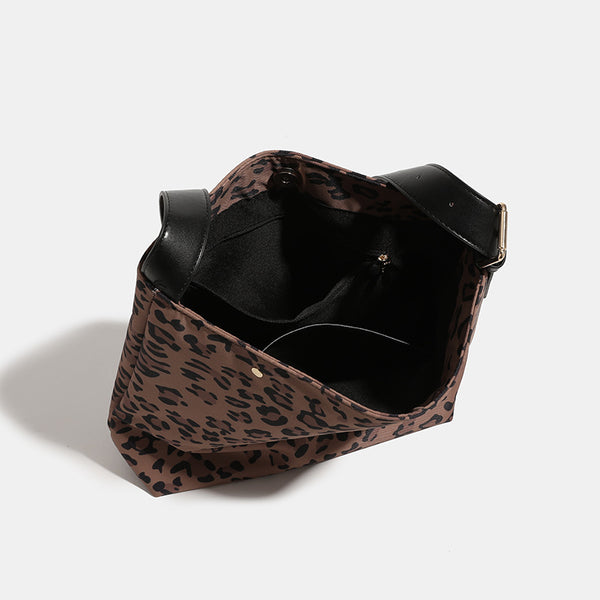 Brown and black leopard print canvas bucket bag with adjustable black leather-look shoulder strap and gold-tone hardware