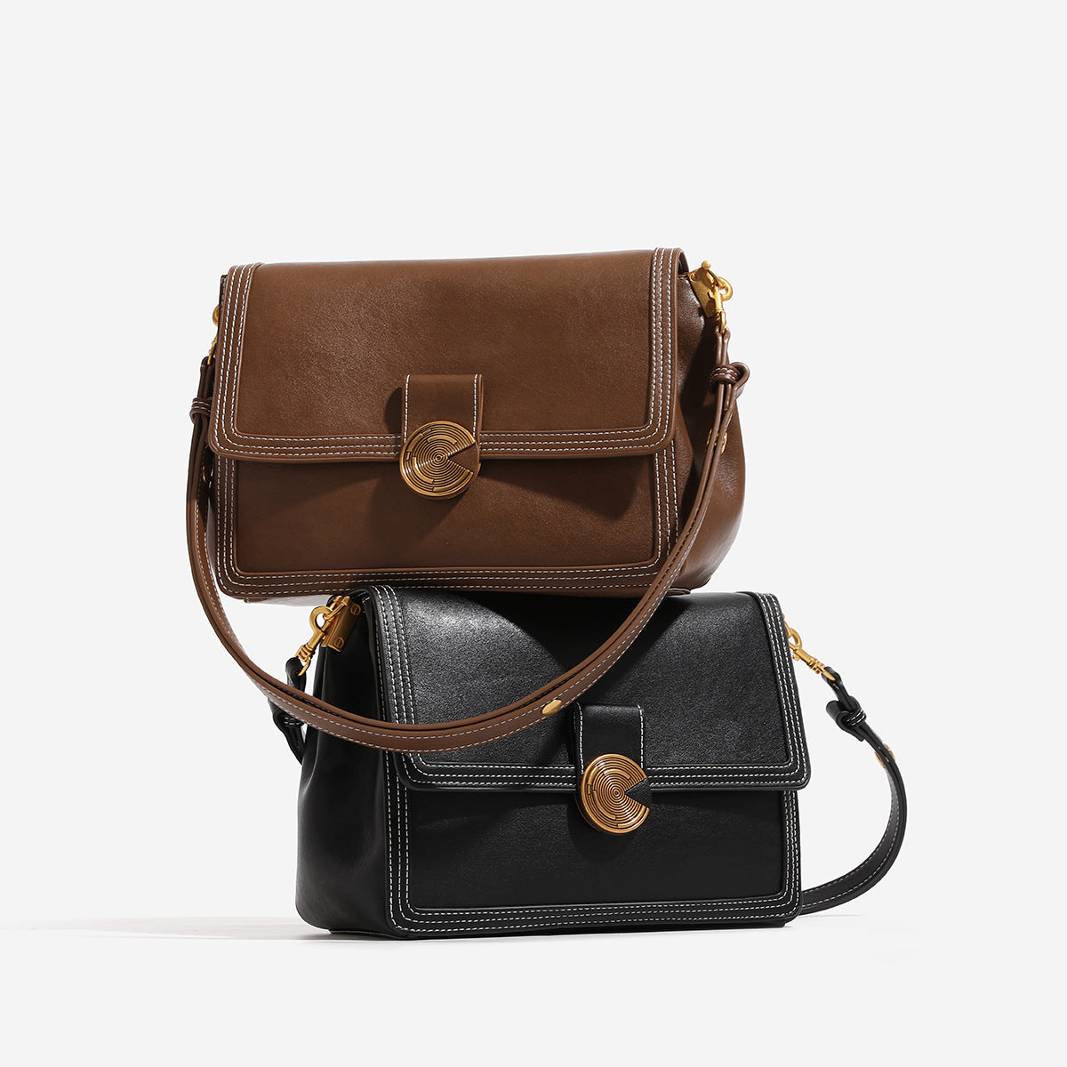 Structured flap shoulder bag with gold-tone circular turn-lock closure, white contrast stitching, and adjustable strap