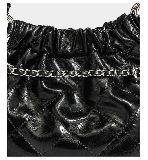 Glossy diamond-quilted drawstring bucket bag with silver chain shoulder strap and medallion charm, detail view 18