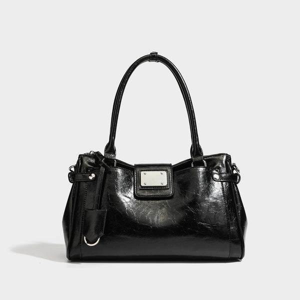 Structured glossy crinkled leather-look satchel with double top handles, front metal-plaque tab, silver-tone hardware, and