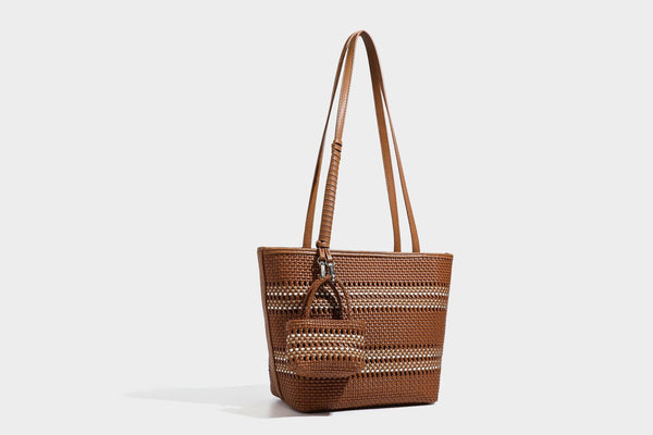 Large structured woven tote bag with striped basket-weave finish, long shoulder straps, and detachable mini pouch charm