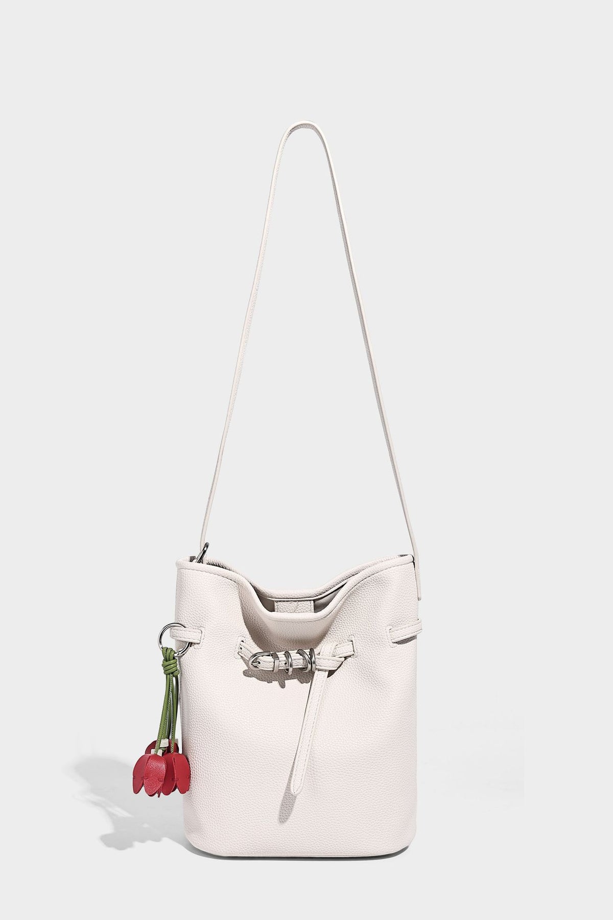 Small pebbled leather-look bucket bag with front drawstring toggle hardware and long adjustable shoulder strap, detail view