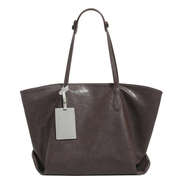 Large leather-look tote bag with trapezoid silhouette, double shoulder straps, and detachable hanging tag, detail view 5