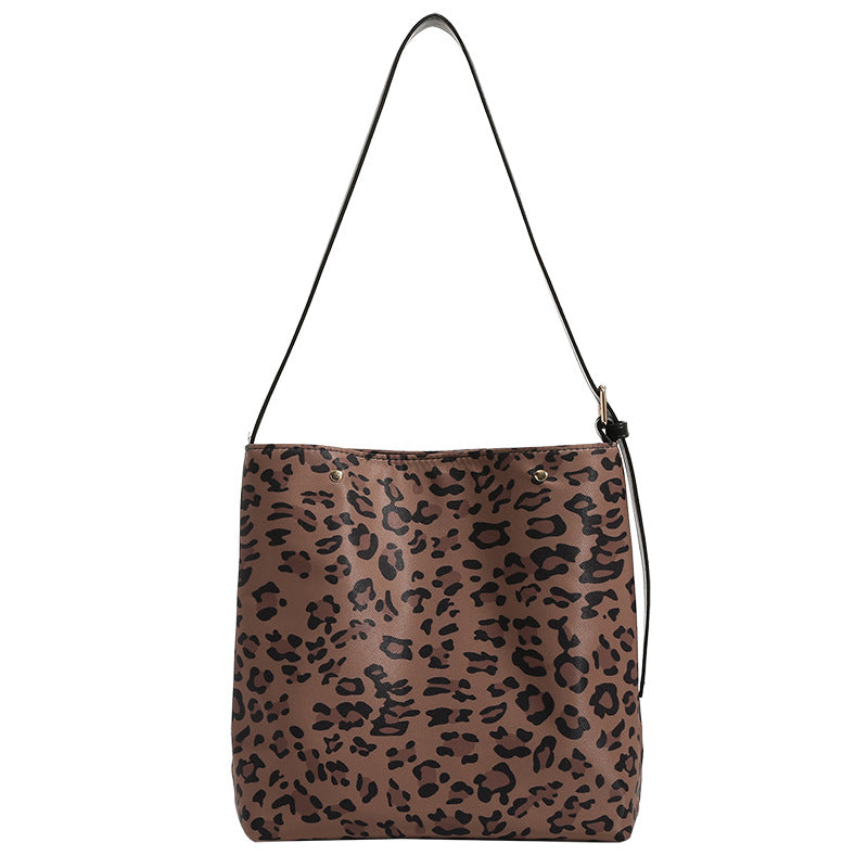 Brown and black leopard print canvas bucket bag with adjustable black leather-look shoulder strap and gold-tone hardware