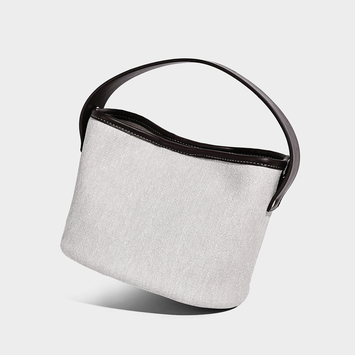 Kleine Bucket-Bag in Denimoptik mit schwarzem Besatz in Lederoptik, Anhänger in Form einer rosafarbenen Tulpenblüte und verstellbarem Crossbody-Riemen, Vorderansicht