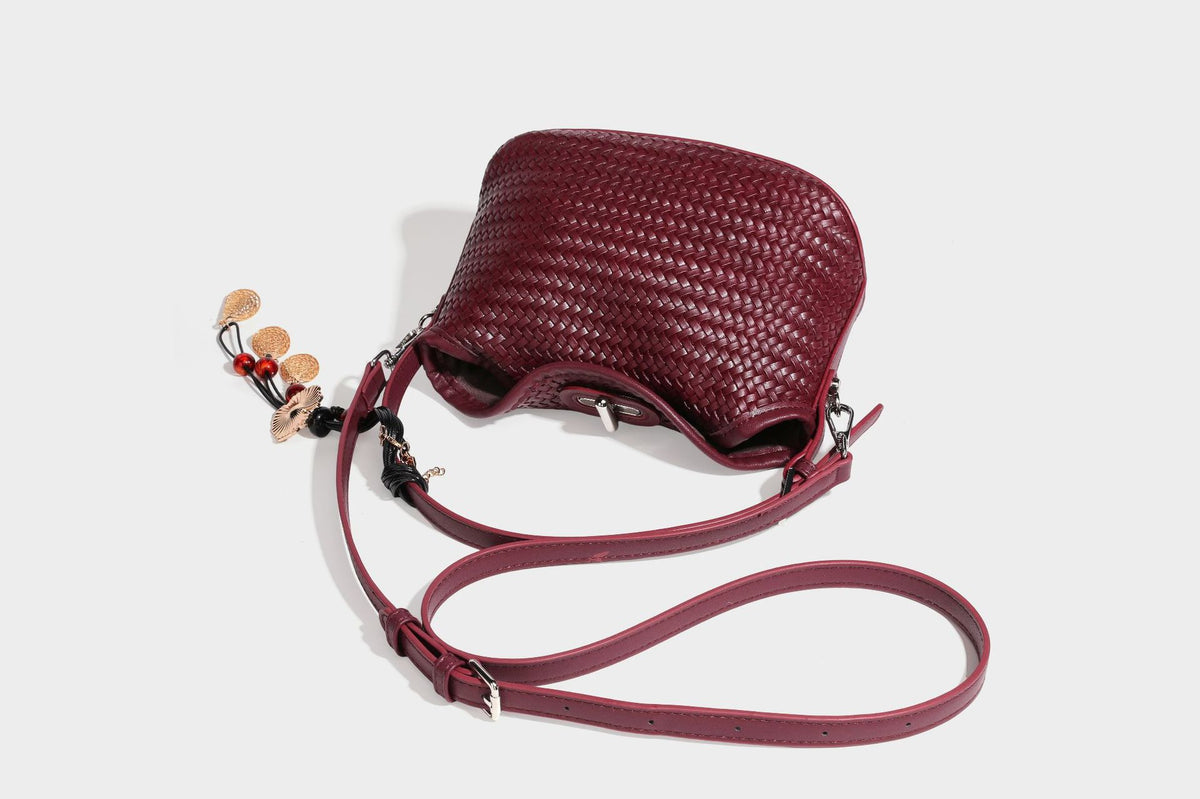 Small woven-look leather-look flap shoulder hobo bag in burgundy with silver-tone hardware and decorative tassel charm