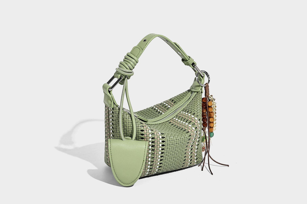 Small woven crescent shoulder bag with leather-look trim, zip closure, silver-tone ring hardware, and beaded tassel charm