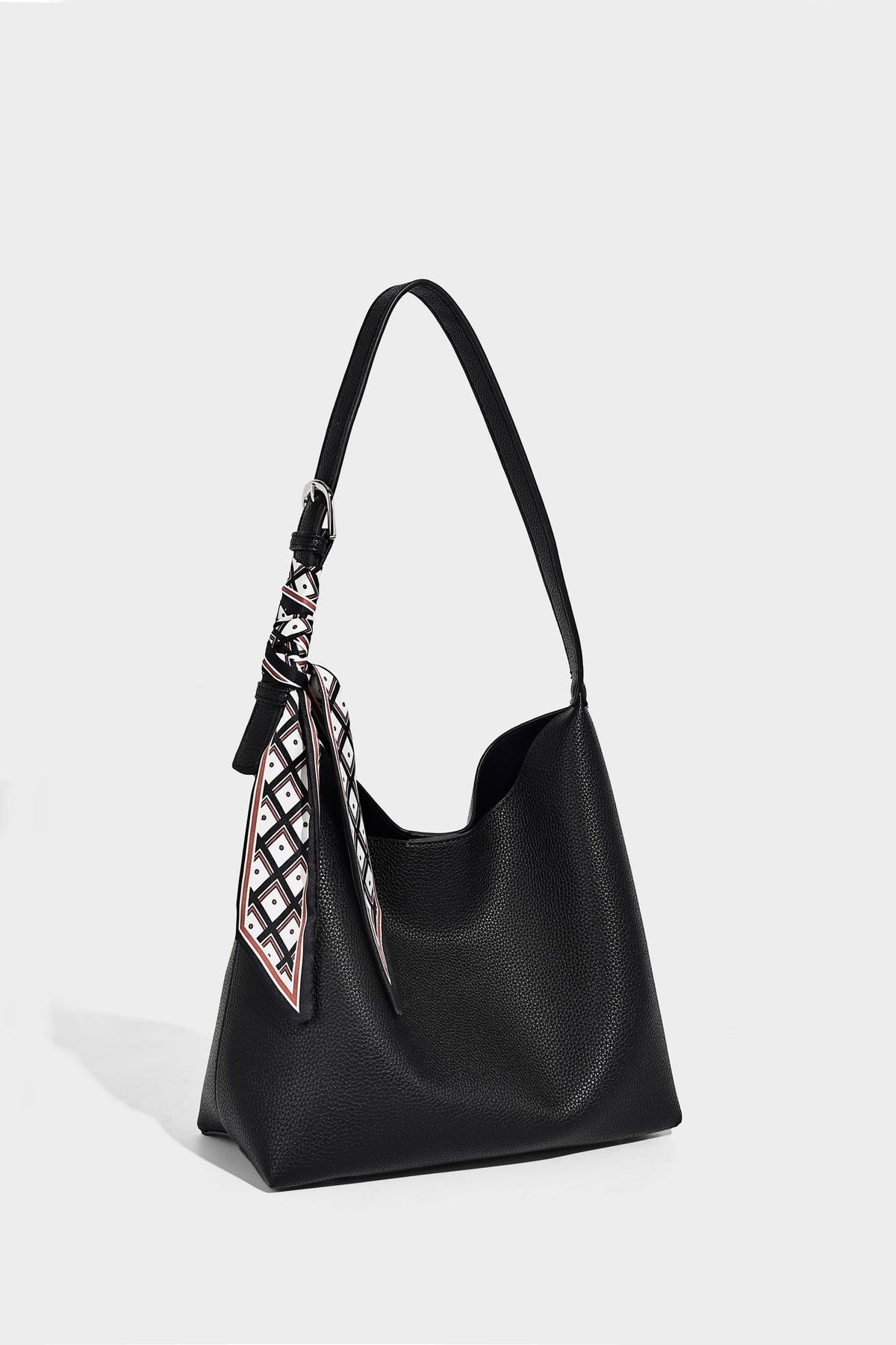 Soft slouchy hobo shoulder bag in pebbled matte finish with slim strap, silver-tone ring hardware, and knotted printed scarf