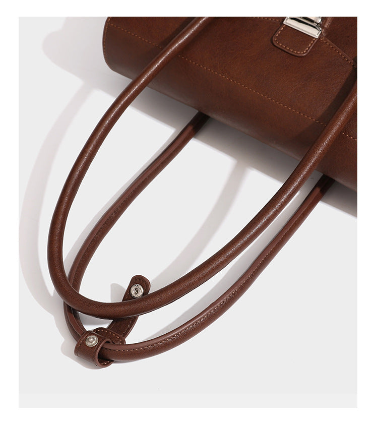 Structured rectangular satchel bag with dual rounded top handles and central metal turn-lock flap closure, detail view 17