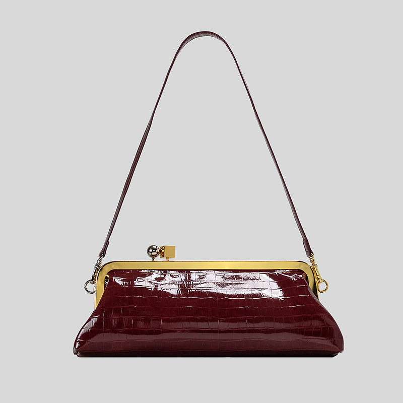 Strukturierte Clutch mit Kiss-Lock-Rahmenverschluss aus dunkelbrauner, krokodil-geprägter Lederoptik mit goldfarbenen Details und schmalem
