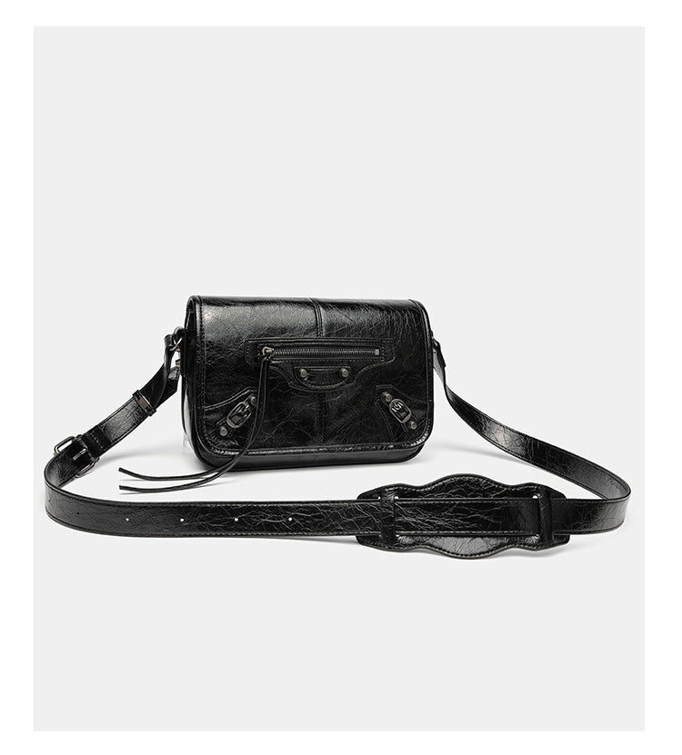 Small structured rectangular crossbody bag with crinkle leather-look finish, front zip pocket, gunmetal stud hardware, and