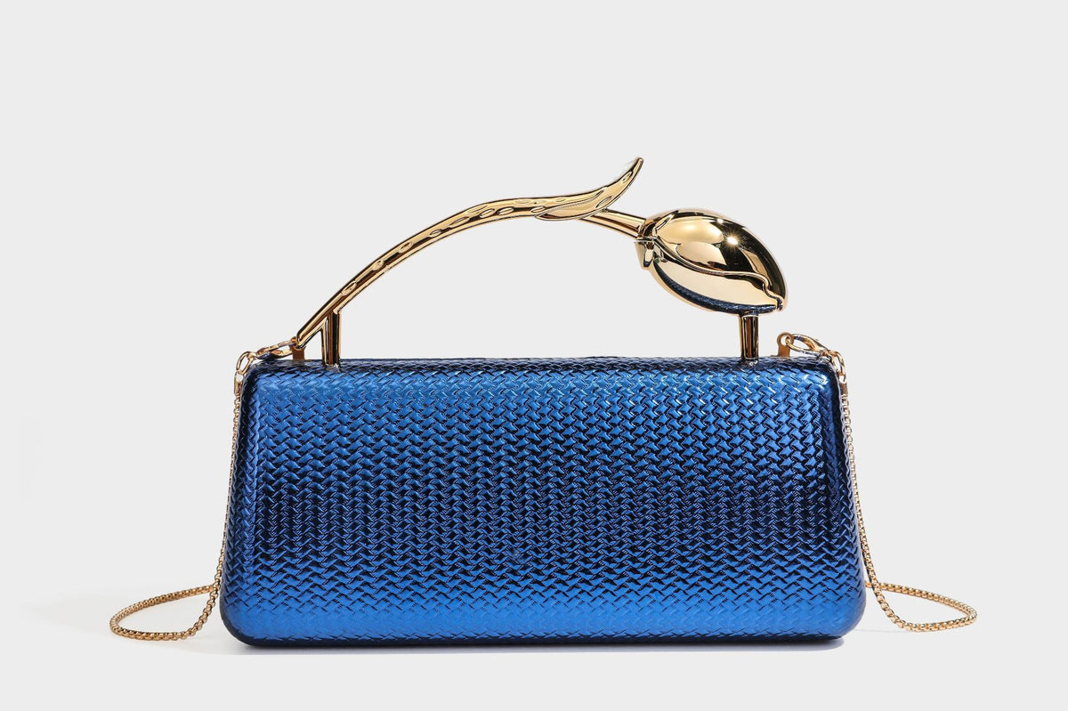 Structured rectangular metallic woven clutch bag with sculptural gold-tone leaf top handle and detachable chain strap, detail