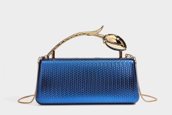 Structured rectangular metallic woven clutch bag with sculptural gold-tone leaf top handle and detachable chain strap, detail