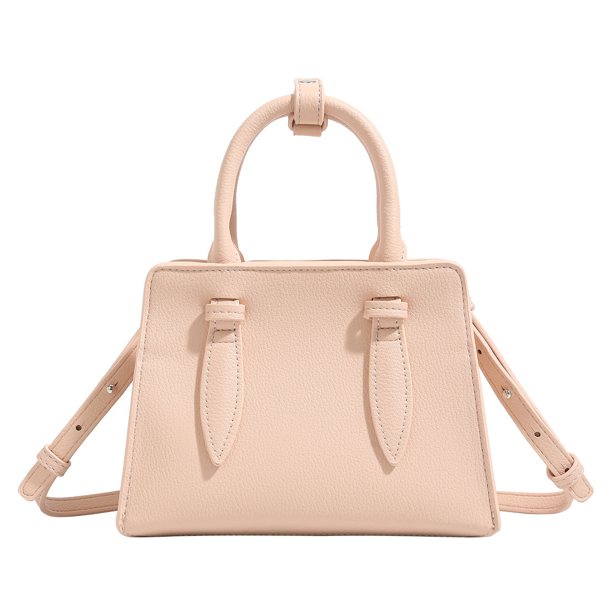 Small structured trapezoid top-handle bag in pebbled matte finish with decorative strap tabs, twin knotted handles, and