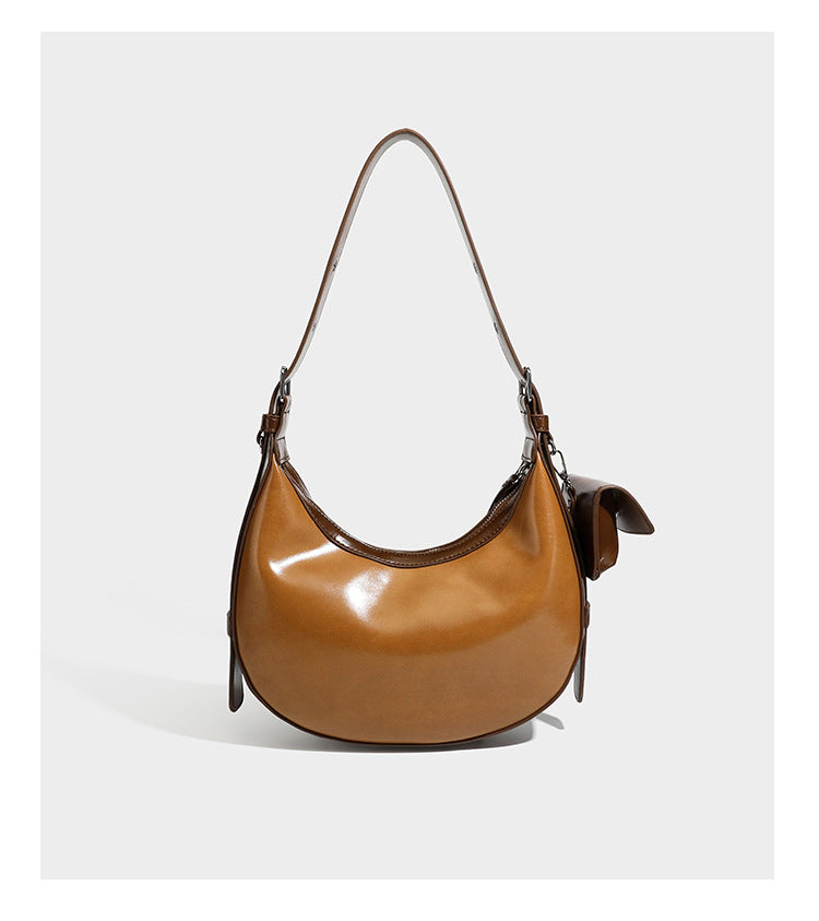 Glossy leather-look crescent hobo shoulder bag with dark contrast trim, silver-tone hardware, and attached mini flap pouch