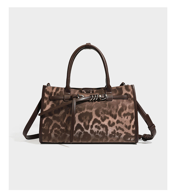 Structured leopard-print tote bag with glossy satin-like finish, dual rounded top handles, silver buckle-and-ring front
