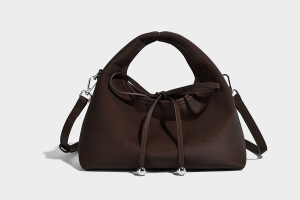 Pebbled matte trapezoid top-handle bag with drawstring bow closure, bead-tipped cords, silver-tone hardware, and detachable