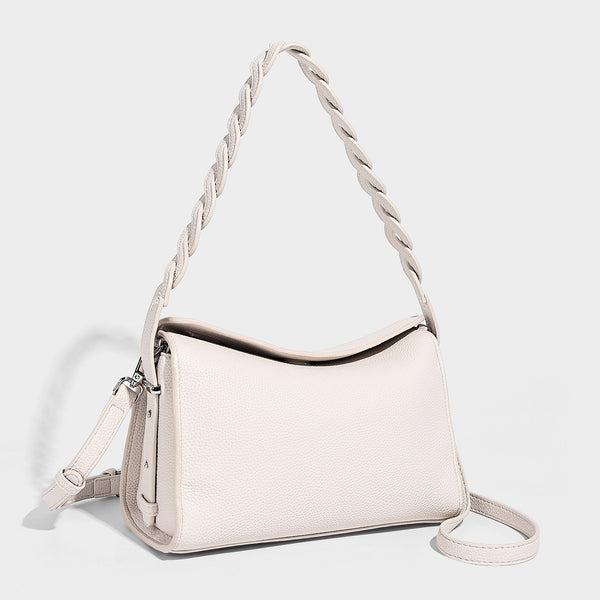 Small structured pebbled-finish shoulder bag with braided top handle, detachable crossbody strap, floral tassel charm, and