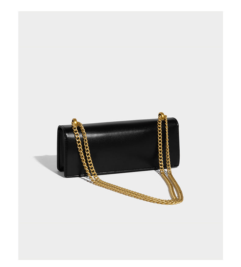 Structured rectangular crossbody bag with glossy finish, three vertical gold-tone embossed plaques, and gold chain strap