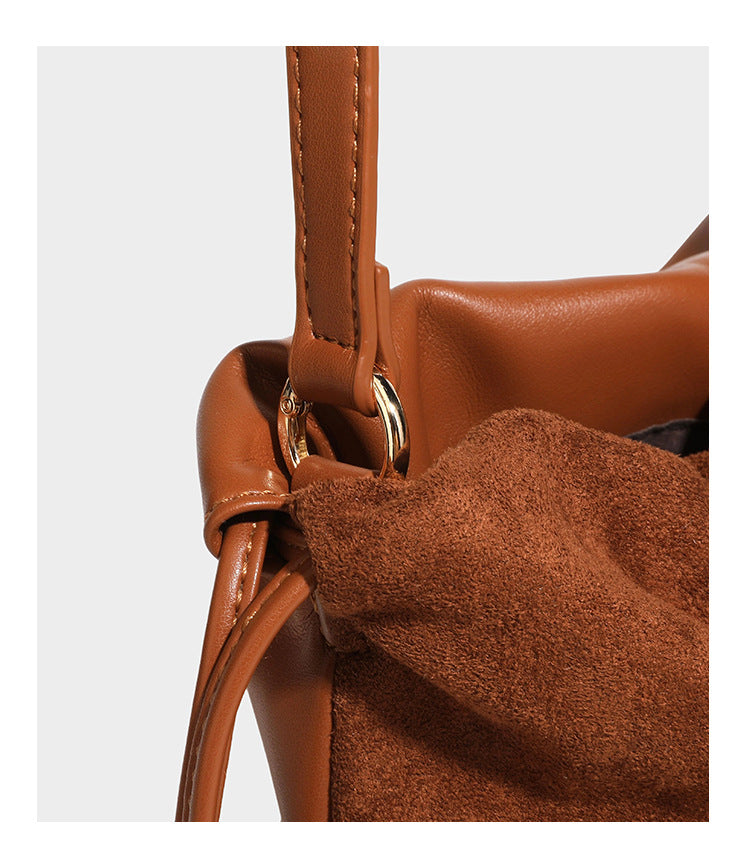 Suede-look drawstring shoulder bag in brown with smooth trim, knotted bead drawstring closure, slim adjustable strap, and
