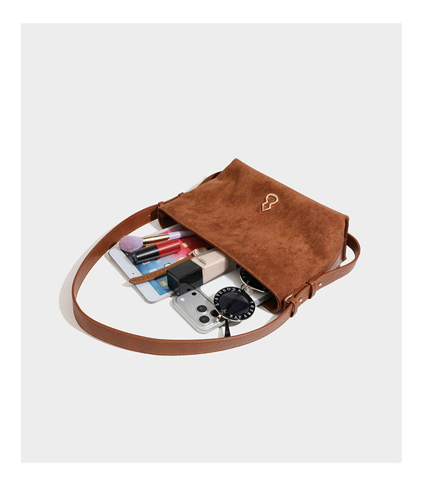 Slouchy suede-finish brown shoulder bag with long single strap and small gold-tone logo emblem on front, detail view 16