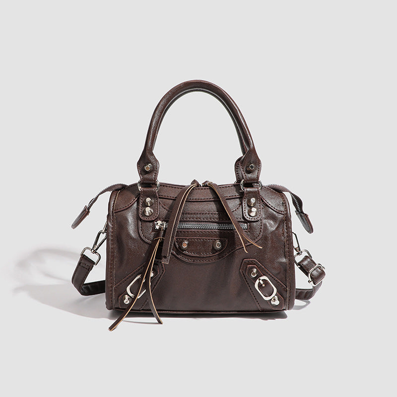 Mini-Henkeltasche mit formstabiler Silhouette, silberfarbenen Nietenbeschlägen, Reißverschlussfach vorne, zwei Tragegriffen und abnehmbarem Schulterriemen