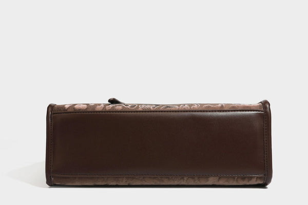 Structured leopard-print tote bag with glossy satin-like finish, dual rounded top handles, silver buckle-and-ring front