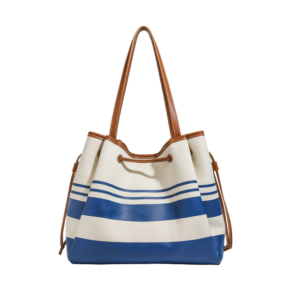 Large cream and navy striped canvas bucket tote bag with tan leather-look trim, drawstring closure, and double shoulder