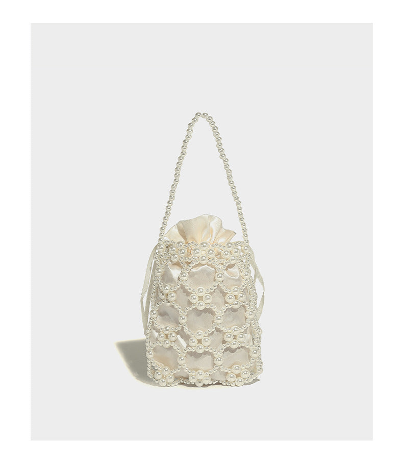 Small pearl-beaded lattice drawstring bucket bag with beaded shoulder strap and ribbon closure, detail view 12