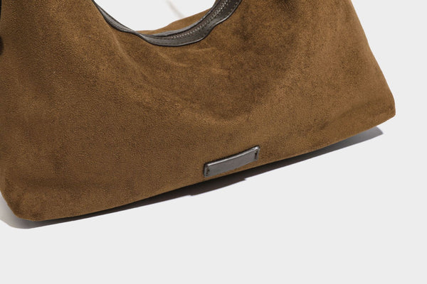 Lässige Hobo-Schultertasche mit matter brauner Wildlederoptik, dunklen glatten Besätzen, Reißverschluss oben und langem, verstellbarem