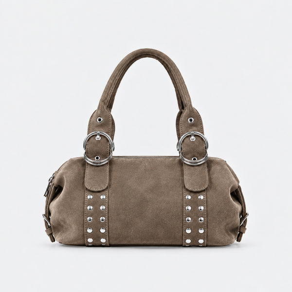 Weiche, matte Schultertasche in Zylinderform aus Veloursleder-Optik mit silberfarbenem Nietenbesatz, Ringschnallen-Details und zwei gerollten Tragegriffen, Detailansicht