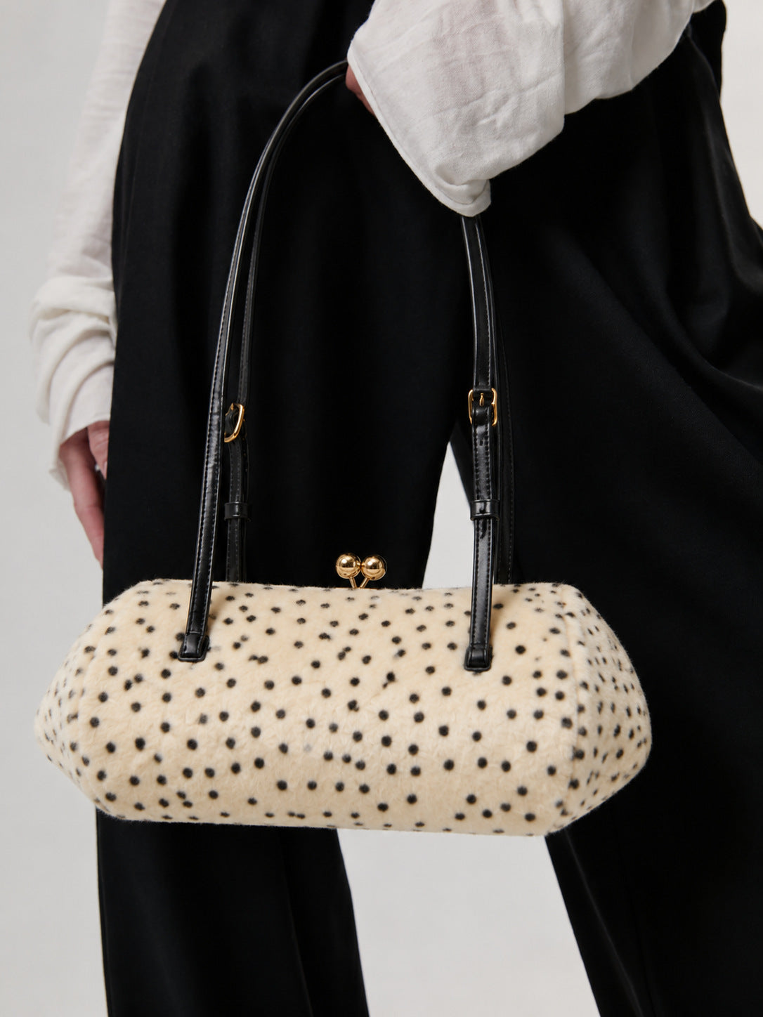 Spotted faux-fur barrel shoulder bag with gold kiss-lock clasp and black adjustable leather-look straps, detail view 11