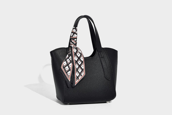 Structured pebbled leather-look tote bag with detachable scarf tie, dual top handles, and adjustable crossbody strap, detail