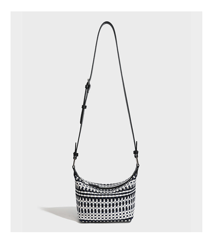 Small crescent shoulder bag in black-and-white woven textile with smooth black leather-look trim, zip-top closure, knotted