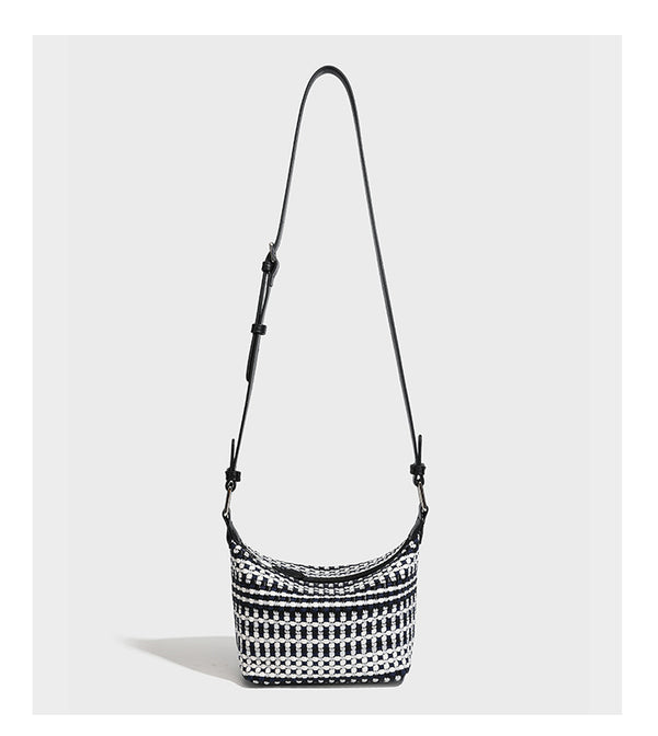Small crescent shoulder bag in black-and-white woven textile with smooth black leather-look trim, zip-top closure, knotted