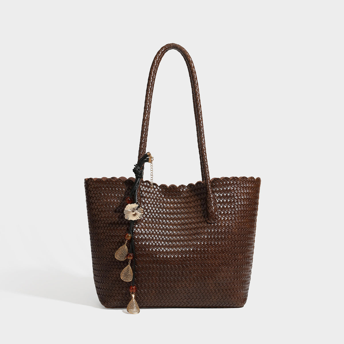 Large open-top woven leather-look tote bag in dark brown with scalloped edge, braided double shoulder straps, and decorative