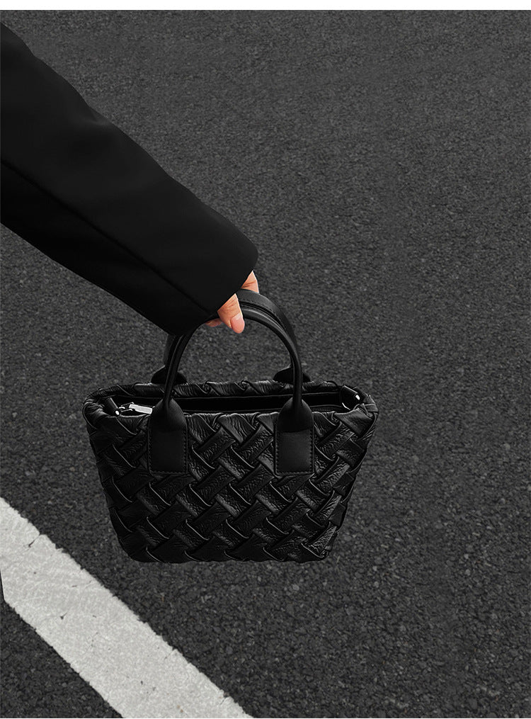 Small black glossy woven tote bag with dual top handles and detachable shoulder strap, detail view 9
