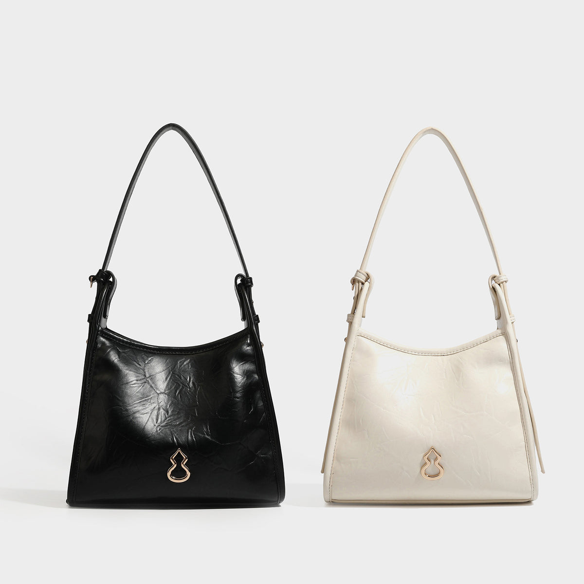 Strukturierte Trapez-Schultertasche mit glänzender, geknitterter Oberfläche in Lederoptik, goldfarbenen Beschlägen an der Vorderseite und langem, verstellbarem