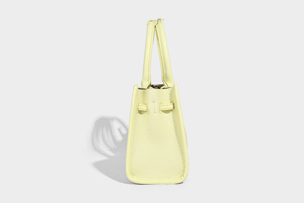 Structured trapezoid tote bag in pebbled leather-look finish with double top handles, silver-tone bar hardware, and, detail