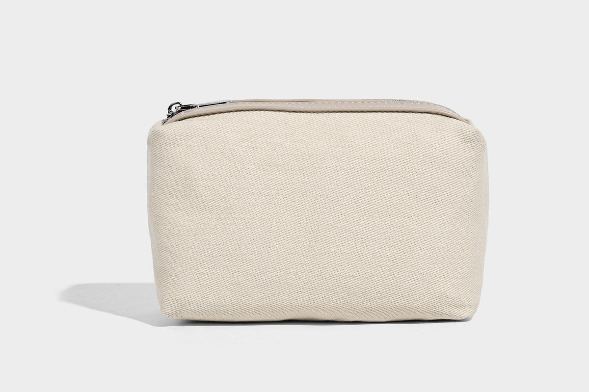 Small pebbled half-moon shoulder bag with dual top handles, detachable crossbody strap, and silver-tone hardware, detail view