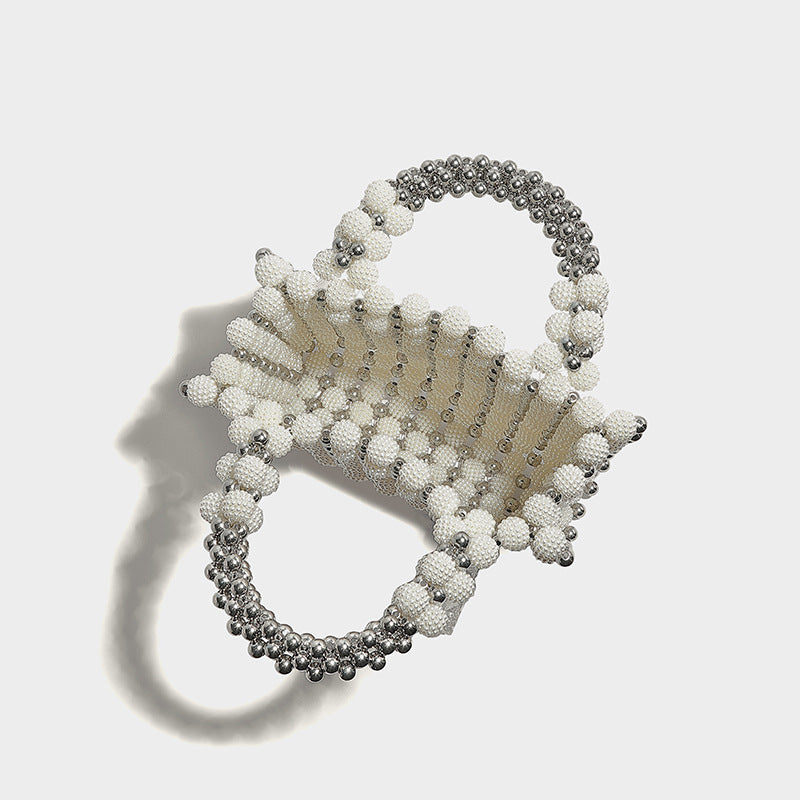 Small boxy pearl-bead mini top-handle bag with silver metallic bead accents, satin floral detail, and long beaded shoulder